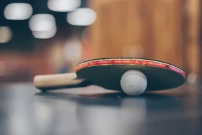 blue table tennis table with a player making a server